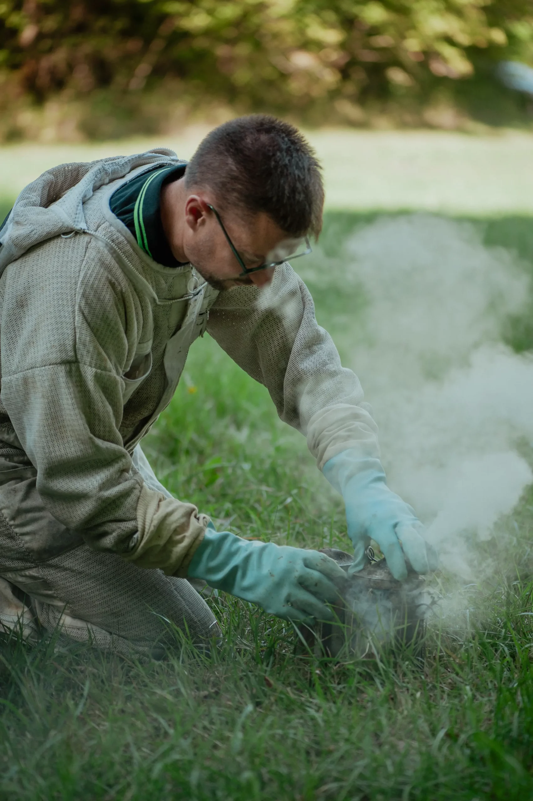 Apiculteur manipulant une ruche dans un rucher du Périgord – Le Rucher du Marandou